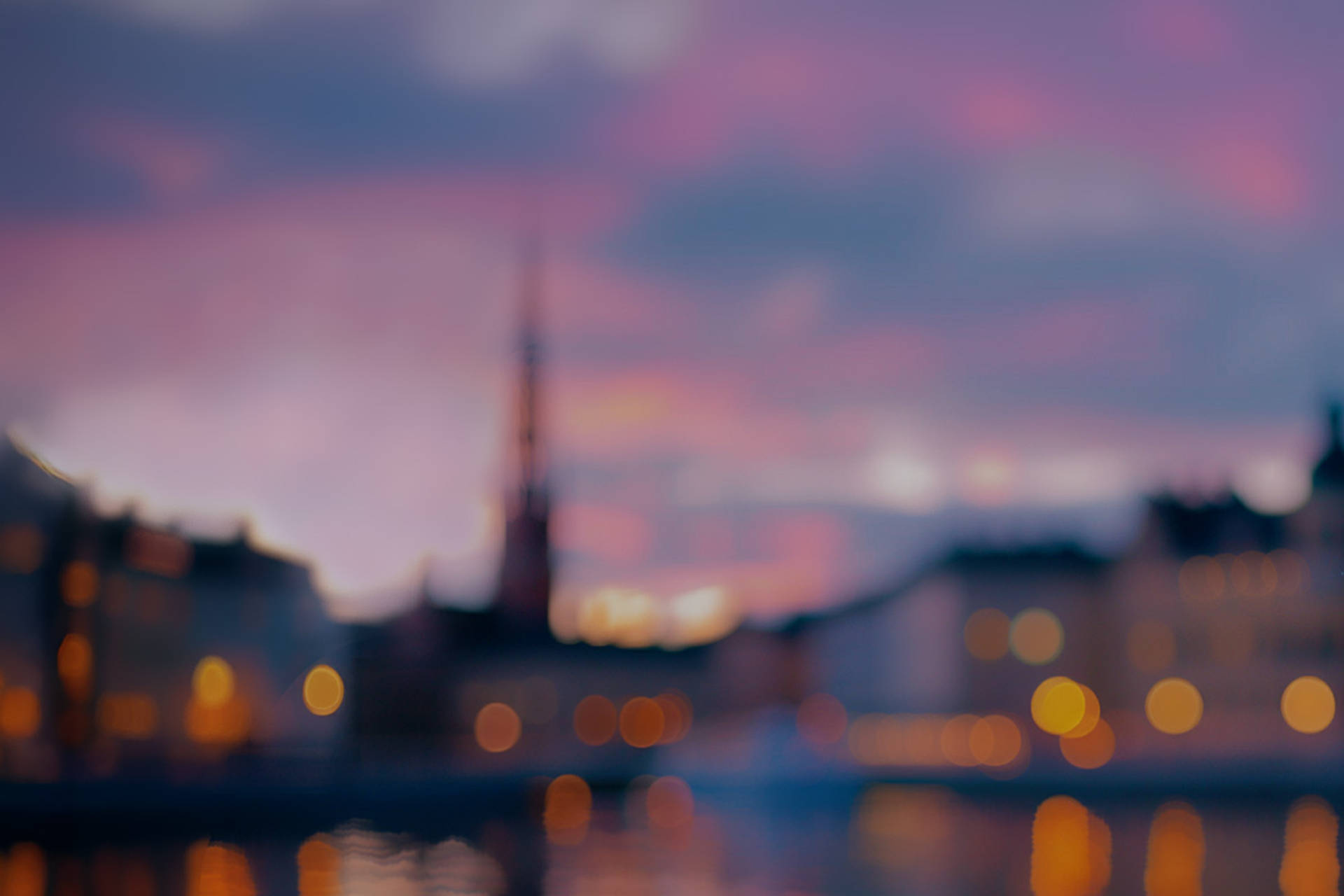 Abstrakt bakgrund med bokeh-effekt och silhuetter av byggnader.